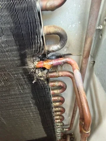 Corroded AC condenser coil with rust buildup on copper tubing and aluminum fins