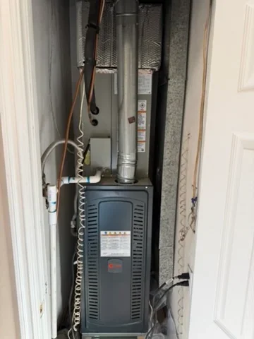 Installed furnace with ductwork, wiring, and control components in utility closet